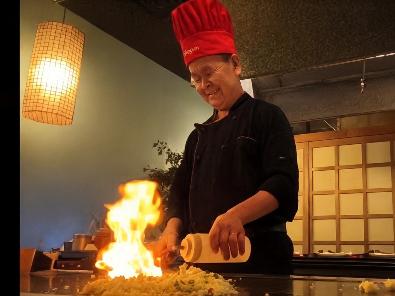 Shogun chef performing hibachi teppanyaki with flames